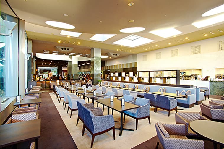 The bright and calm Lobby Lounge features tables and chairs neatly arranged.