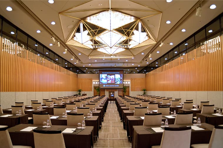 Interior view of a large hall with high ceilings and neatly arranged seating.