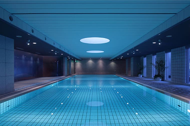 A quiet indoor swimming pool with lighting.