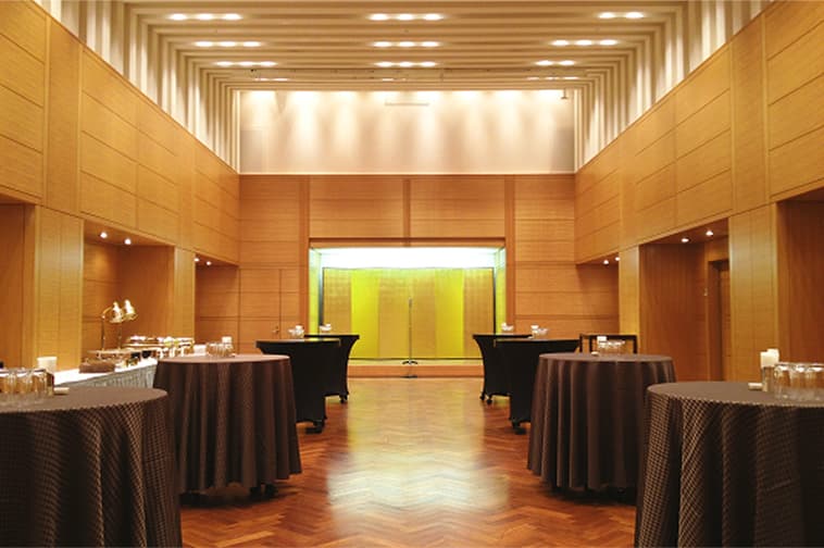 A medium-sized event hall featuring wood-grain walls and distinctive lighting.