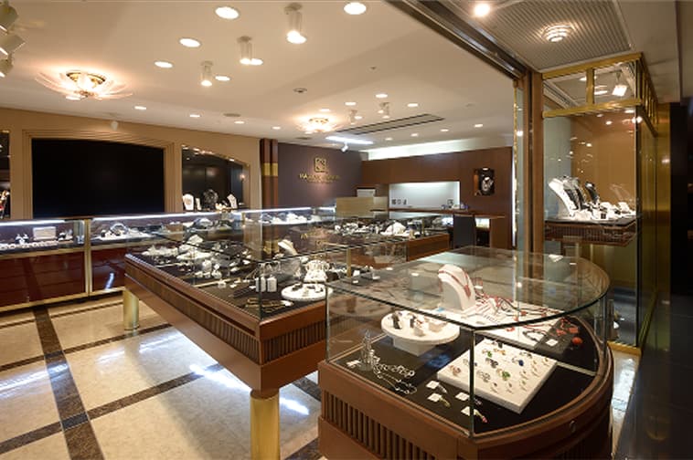 The interior of an elegant jewelry shop with jewelry displayed in glass cases.