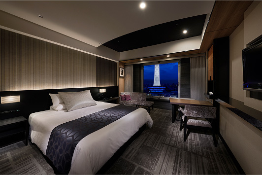 A panoramic view of a modern and sophisticated hotel room, illuminated by soft, subdued lighting.