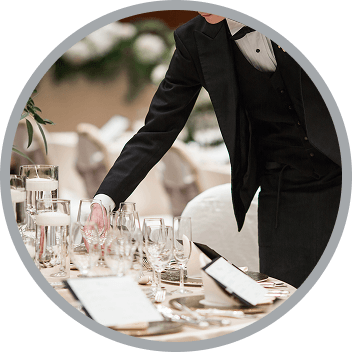 Staff in formal attire setting the tables