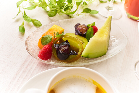 A fruit platter featuring strawberries, melon, grapes, oranges, and other fruits.