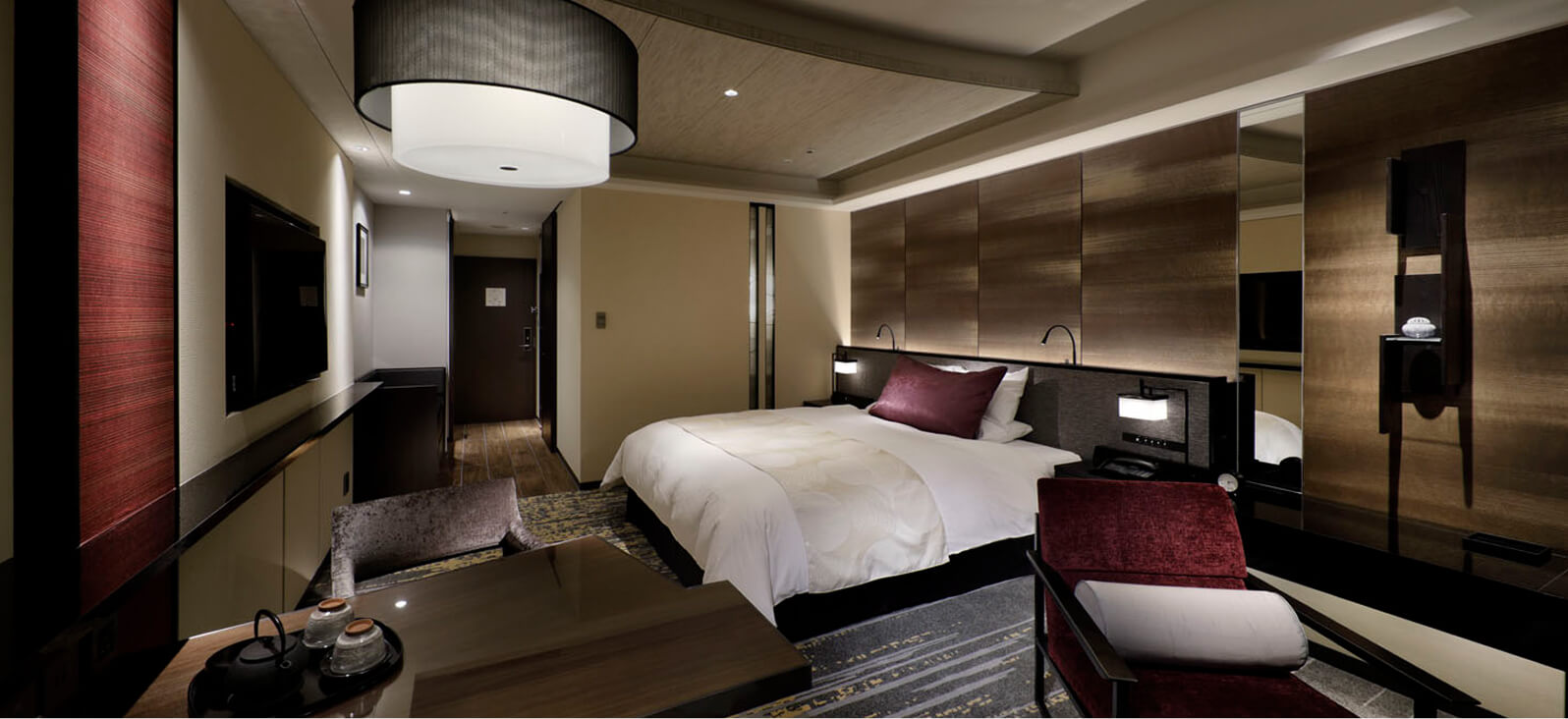 A classic-designed bedroom with a striking red chair.