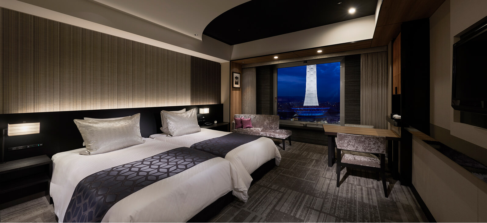 Interior view of the twin-bedroom room, offering panoramic night views from the upper floors.