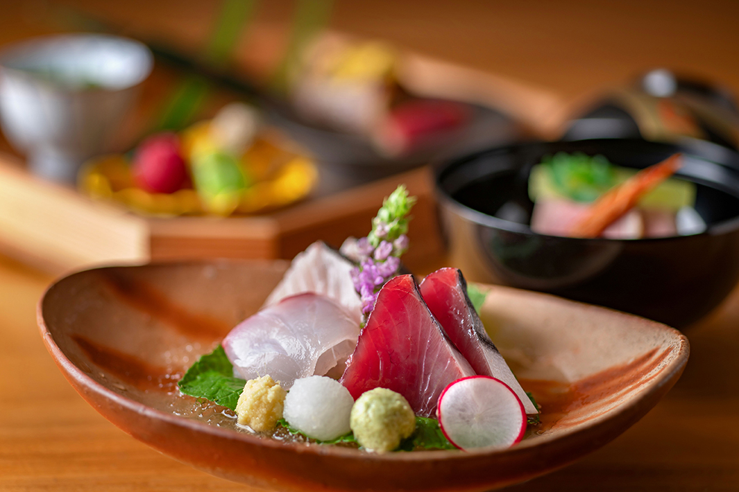 白身魚の前菜にライムの皮を削って香りを加えるシーン。美しい盛り付け。