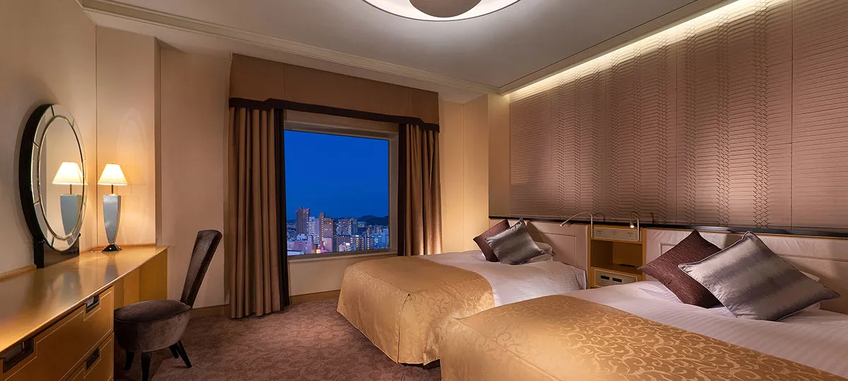 夜景を望む大きな窓と広めのベッドがあるモダンな客室