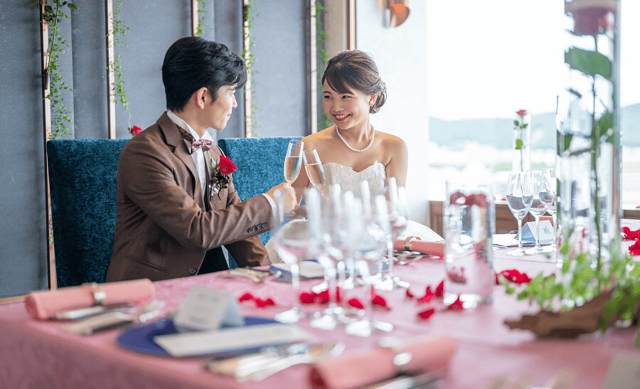 紫色の装飾が施されたテーブルが並ぶ、広々とした結婚披露宴会場です。