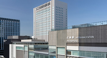 写真：JR広島駅新駅ビル周辺。手前には駅前広場や駐輪場、大きなショッピングセンターがある。左奥にはホテルグランヴィア広島サウスゲートが見える。