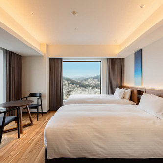 Photo: Room with two beds and a large window in the back