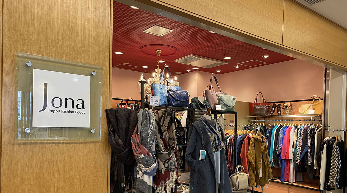 色鮮やかなウェアやストール、バッグが並ぶインポートファッショングッズ「ジョナ」の店頭