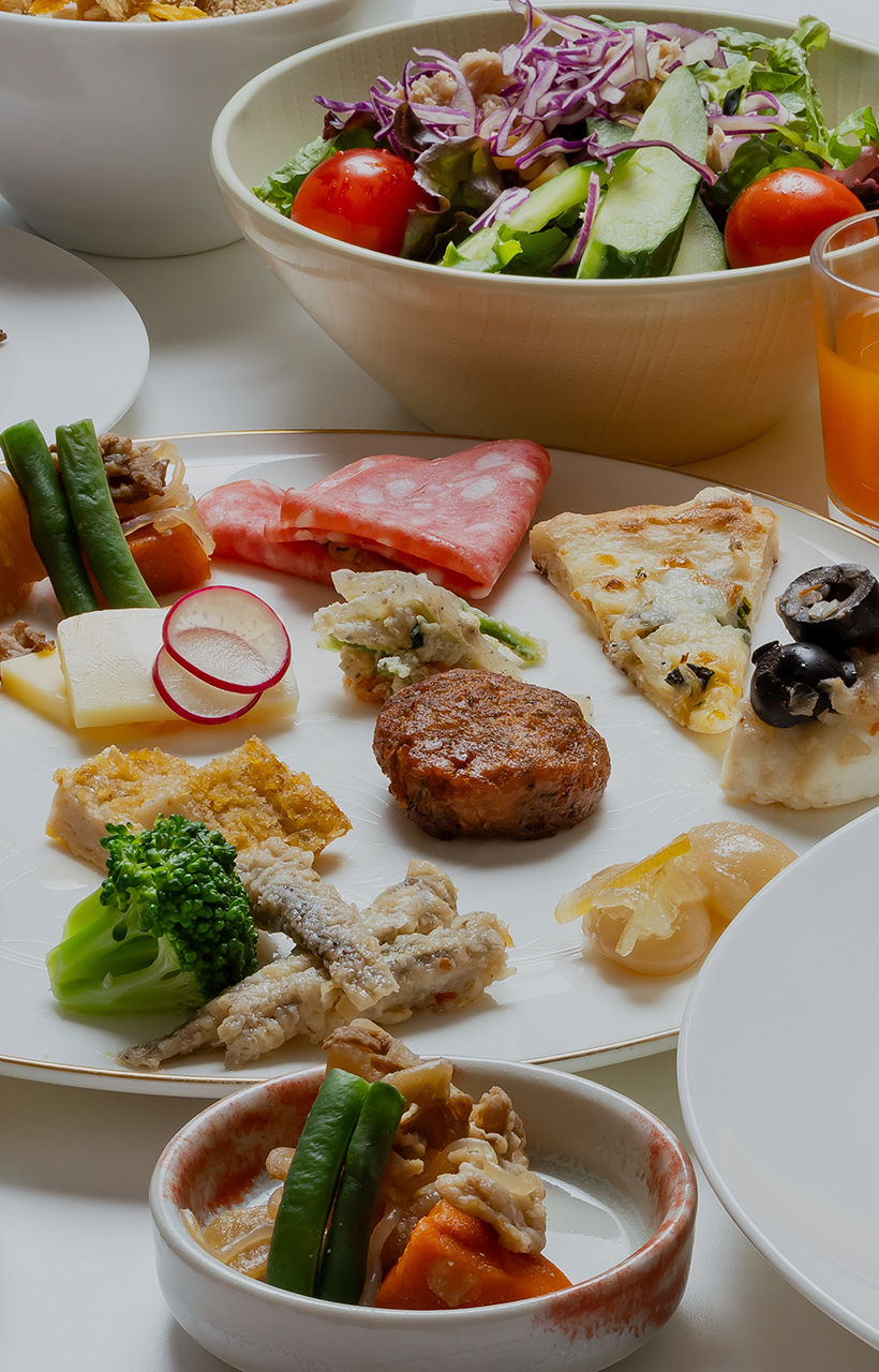 色鮮やかな前菜やオムレツ、焼き魚、焼きたてパン、フルーツなどが美しく並ぶ豪華な朝食ビュッフェ