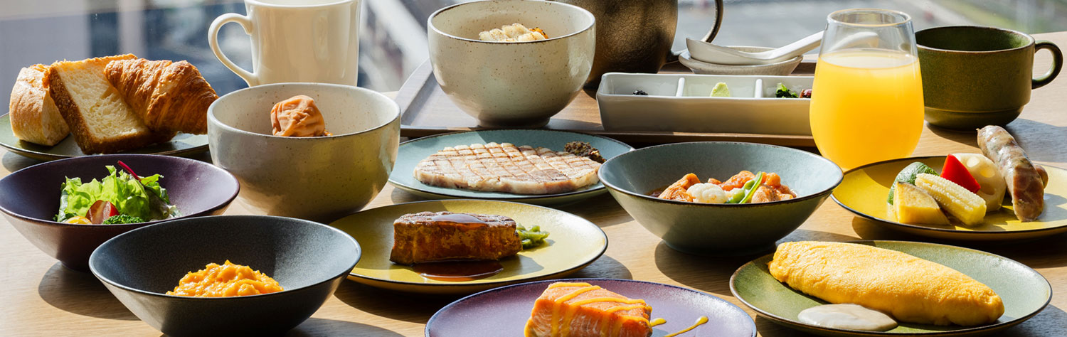グランヴィアラウンジの朝食。オムレツや魚料理、パン、サラダなどの多彩な料理が並ぶテーブル。