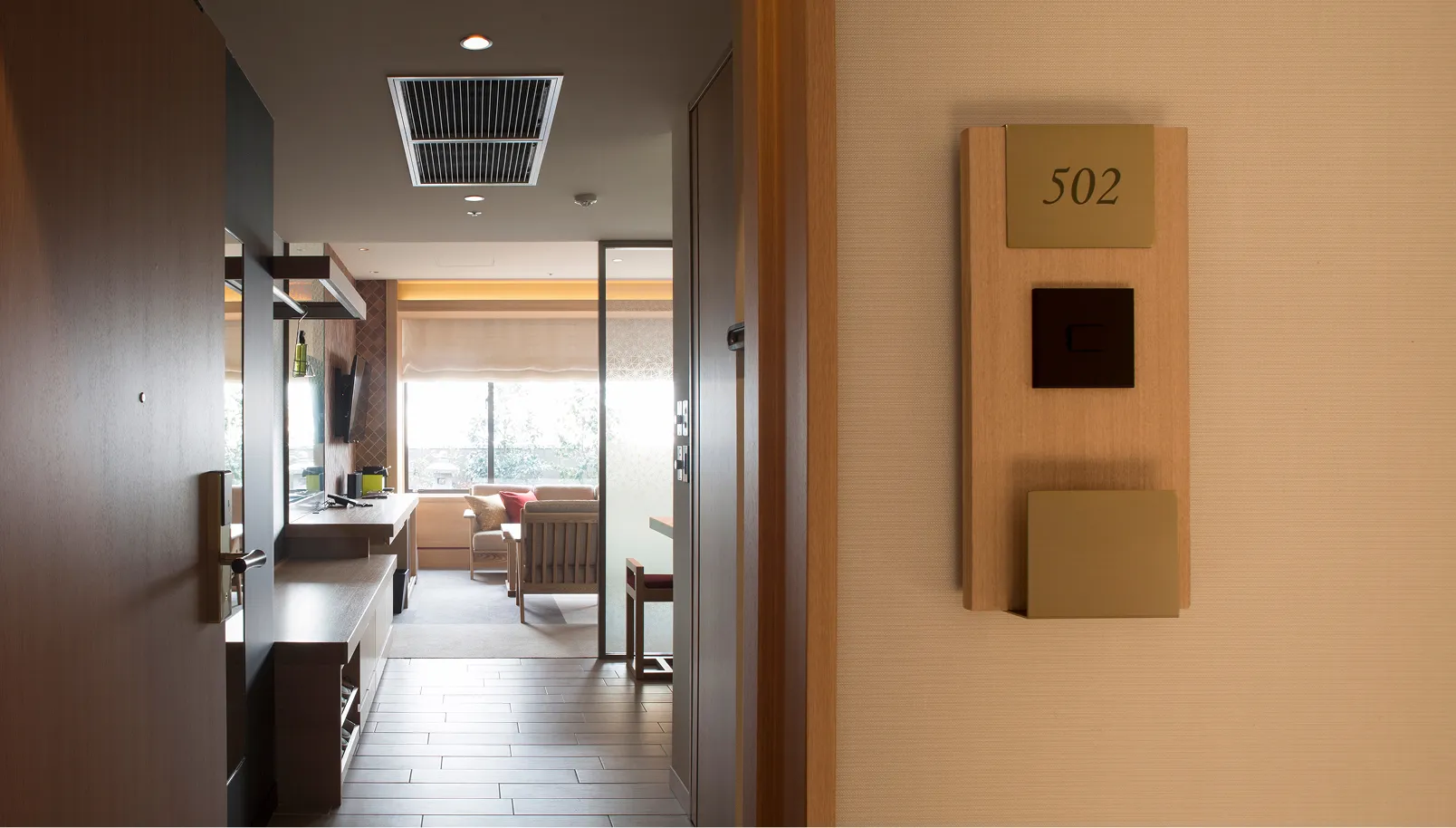 木目調の壁と青いクッションが印象的な高級感のあるツインルーム