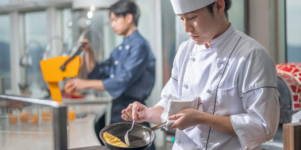 2段のトレイに並べられたクロワッサンやデニッシュなど、焼き立ての様々な種類のパン。