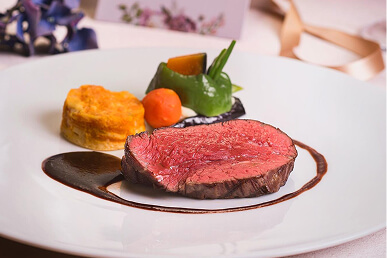お正月らしい華やかな和食の盛り合わせと、洋風の肉料理やデザートが並んでいます。