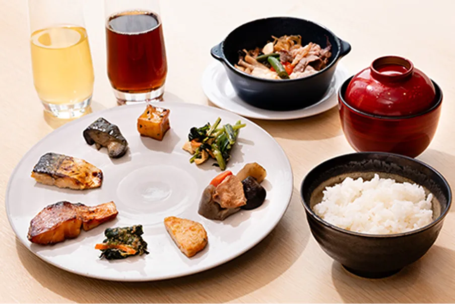 焼魚やお浸し、ひじきなどの和惣菜に、大阪らしい生姜天、ふっくら炊き上がったご飯とお粥が並ぶ日本の伝統的な朝食膳。