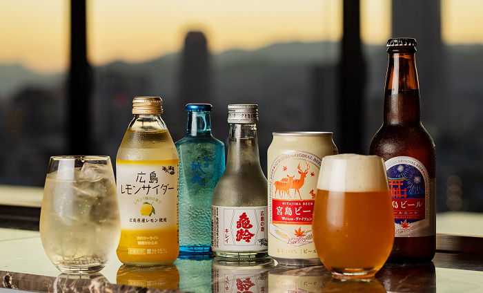 夕景を望む窓際に並ぶ地ビールや地酒などのご当地ドリンク