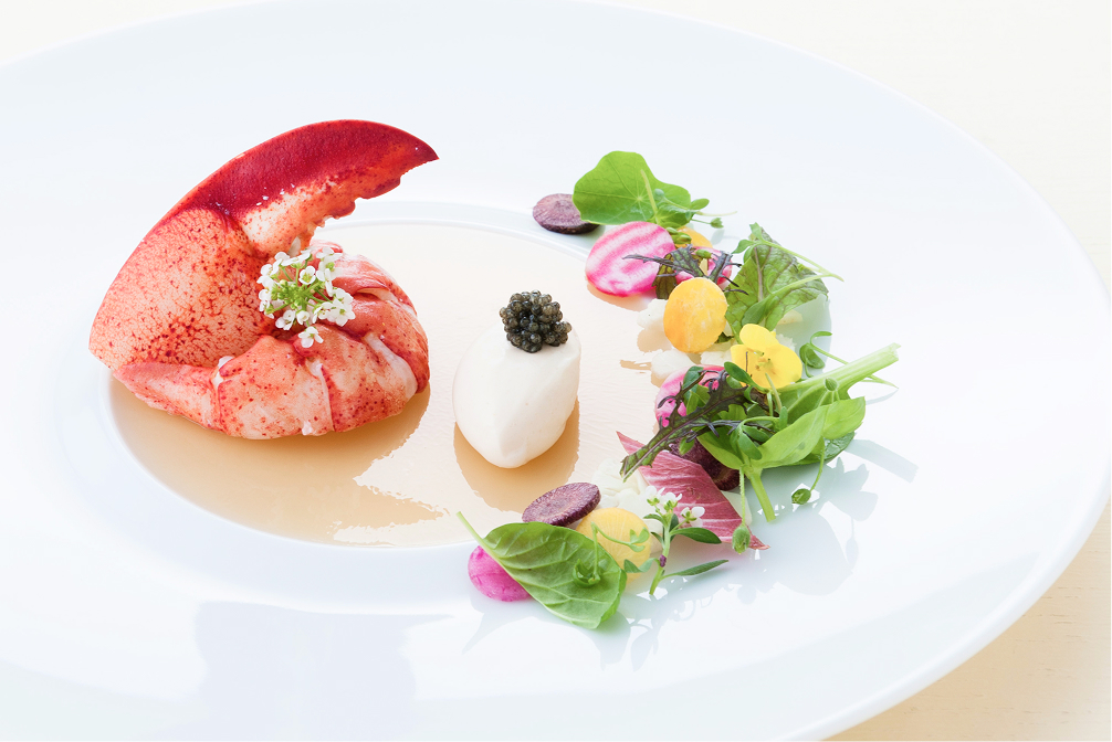 白い皿に美しく盛り付けられた前菜と白ワインのグラス