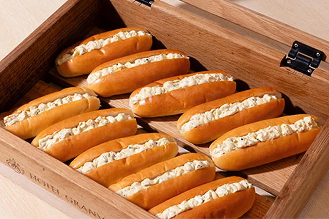 木箱に並べられた、卵サラダを挟んだホテルグランヴィアの朝食ブッフェ用ロールパン。