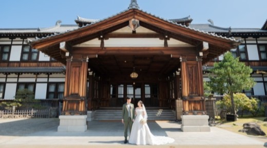 奈良ホテル玄関前で見つめ合う新郎新婦