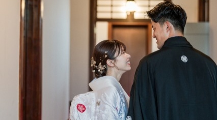 和装を着て見つめ合い笑う新郎新婦