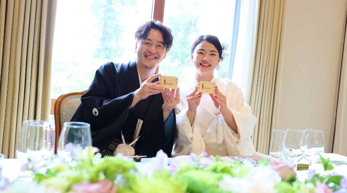鏡開きの木桝を持って笑顔の新郎新婦