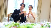 鏡開きの木桝を持って笑顔の新郎新婦