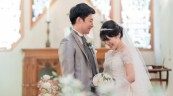 チャペルで洋装を着て笑い合う新郎新婦