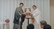 和装新郎新婦がだるまを持っている