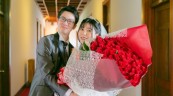 バラの花束を抱える新婦に寄り添う新郎