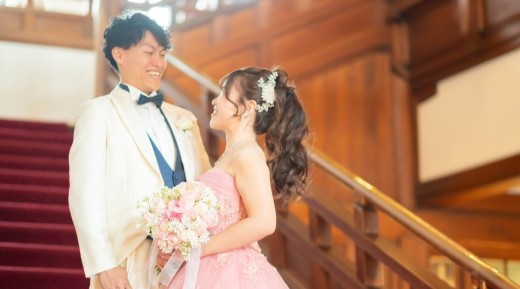 白のタキシードの新郎とピンクのカラードレスの新婦