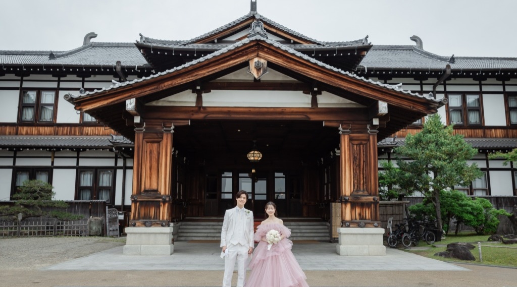 正面玄関前で手を繋ぐ新郎新婦