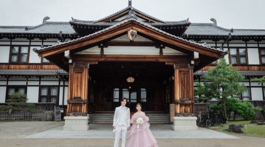 正面玄関前で手を繋ぐ新郎新婦