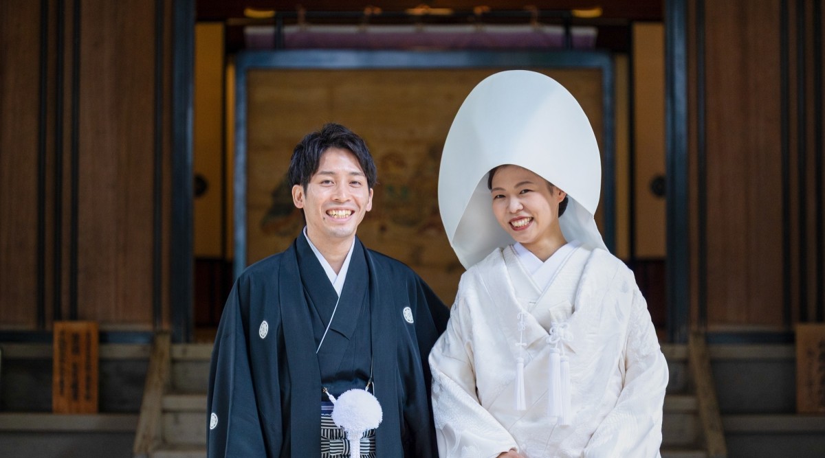 紋付袴と白無垢を着て笑顔の新郎新婦