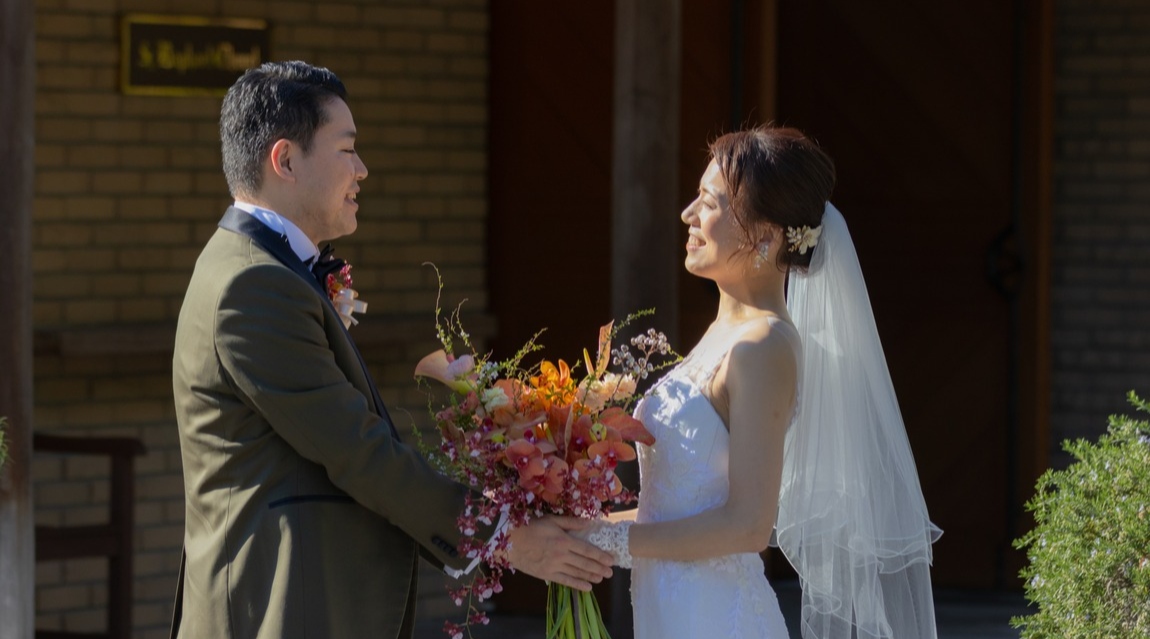 チャペル前で向かい合って手を取り合う新郎新婦