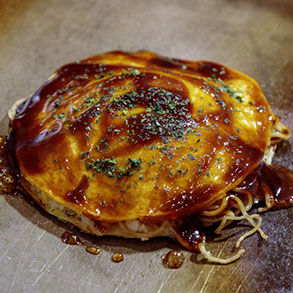 鉄板の上で焼き上げられた出来立て熱々の広島お好み焼き