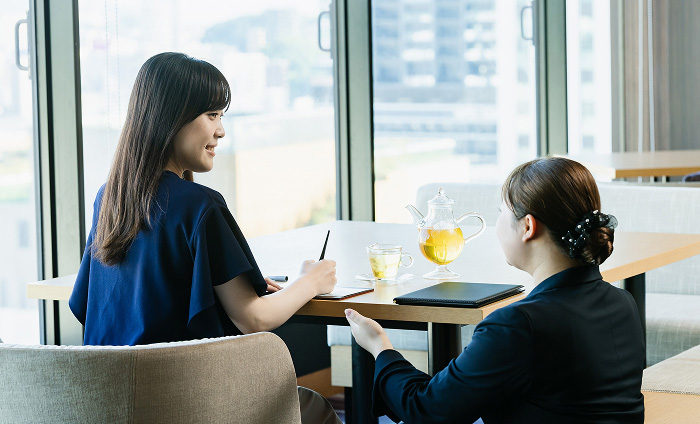 スタッフと笑顔でチェックイン手続きを行う女性