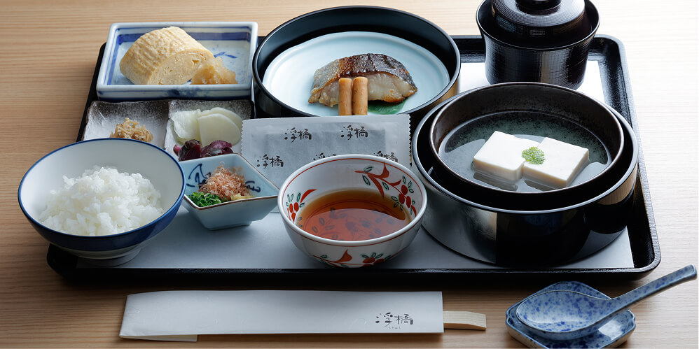 焼き魚やだし巻き卵、ご飯などが並ぶ、和食の朝食膳。