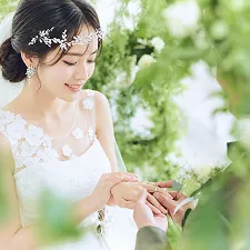 指輪交換を見つめ微笑むウェディングドレス姿の新婦