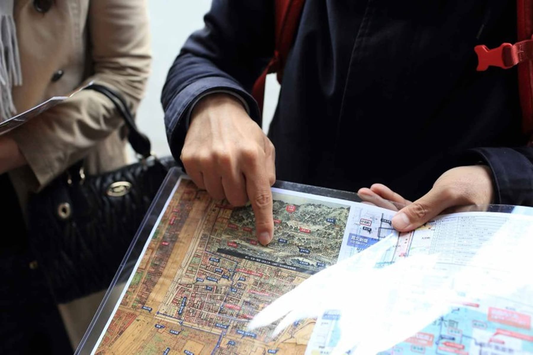 地図を指差し観光ルートを確認する旅行者