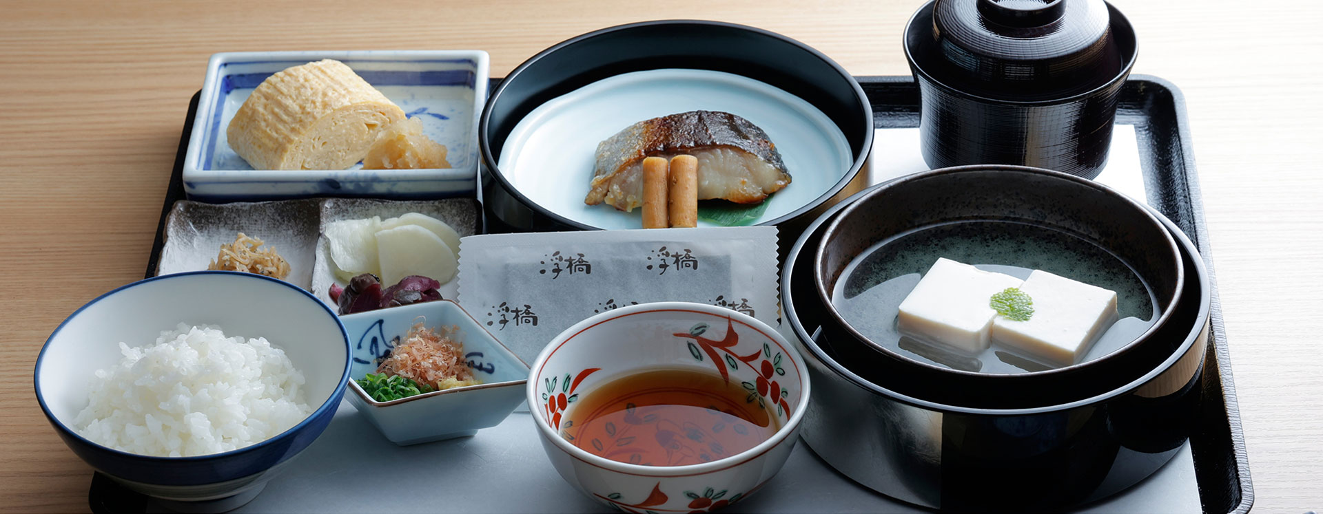 日式早餐的膳食。整齐摆放着烤鱼、豆腐、煎鸡蛋、小菜、米饭、味噌汤等的日本料理的早餐套餐。