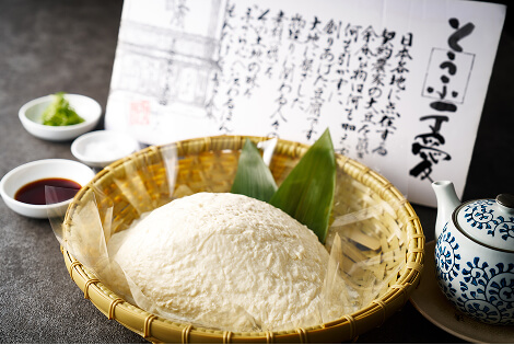 放在笊篱里的豆腐。里面摆放着豆腐的说明书、酱油和佐料等。