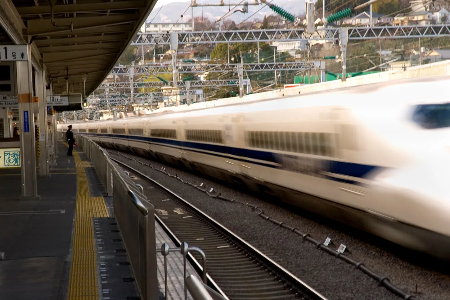 駅のホームを疾走する新幹線