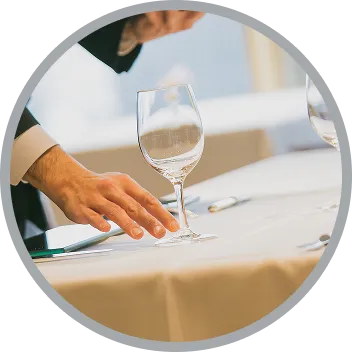フォーマルな服装でテーブルを整えるスタッフ